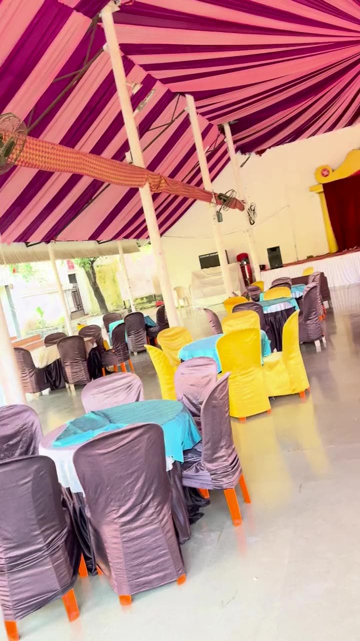 The open hall at Sai Samrat with draped ceiling and stage