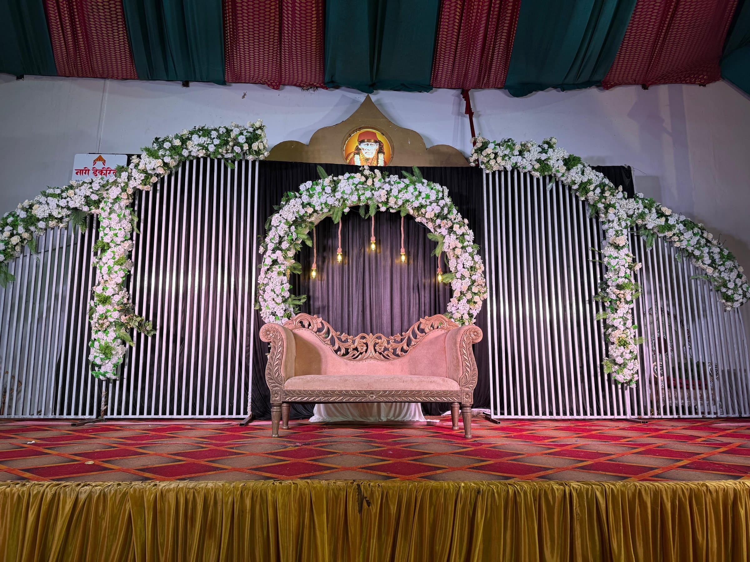 White floral arch stage with carved sofa